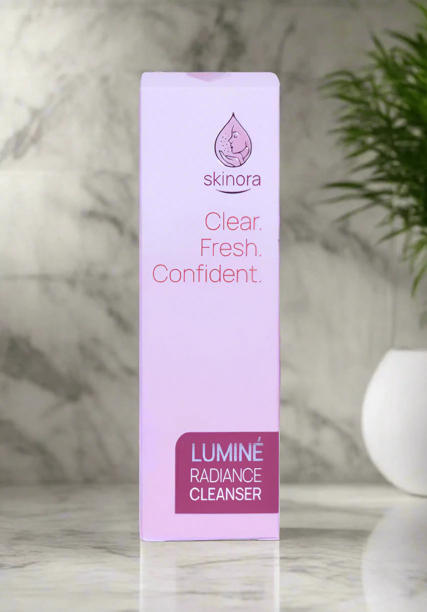 Skinora Luminé Radiance Cleanser packaging on a marble background