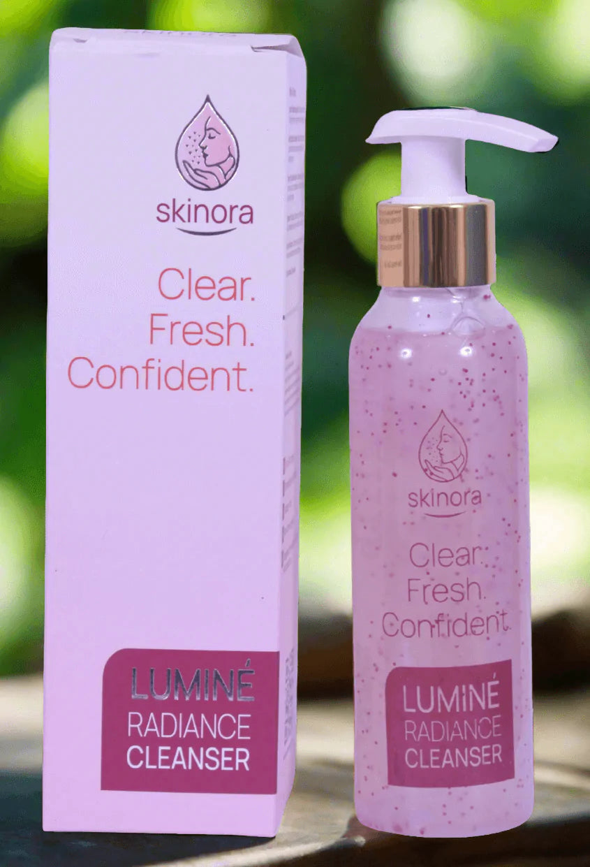 Skinora Lumine Radiance Cleanser bottle and packaging on a blurred green background