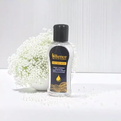 Silkence hair care serum bottle with white flowers in the background